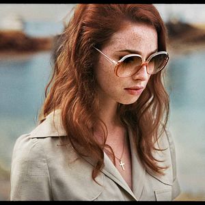 Foto Uma Dama de Óculos Escuros com uma Arma no Carro