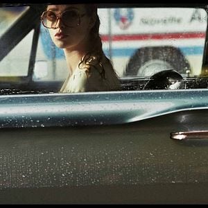 Foto Uma Dama de Óculos Escuros com uma Arma no Carro