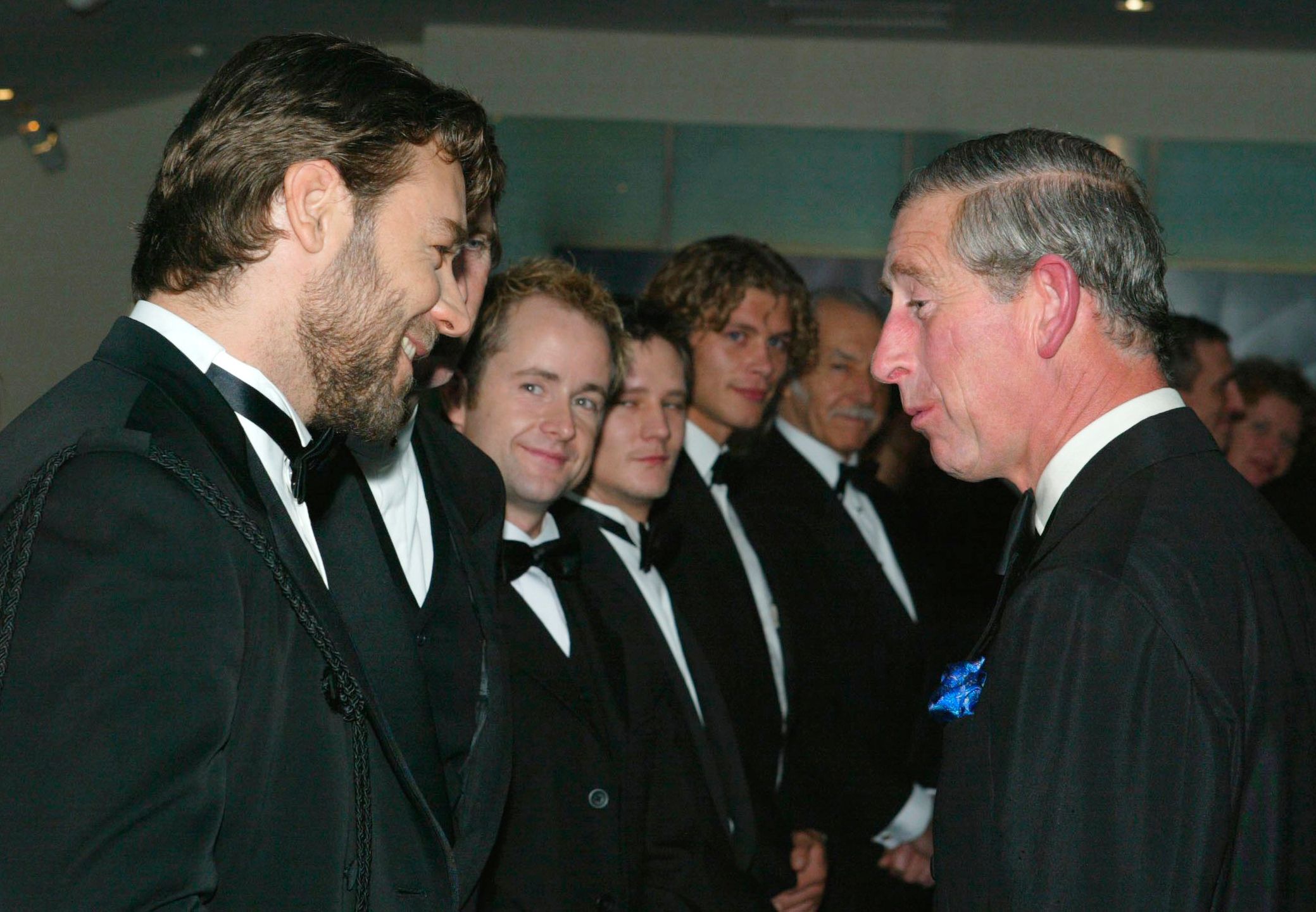 Russell Crowe cumprimentando o então príncipe Charles na première de Mestre dos Mares - O Lado Mais Distante do Mundo, em novembro de 2003.
